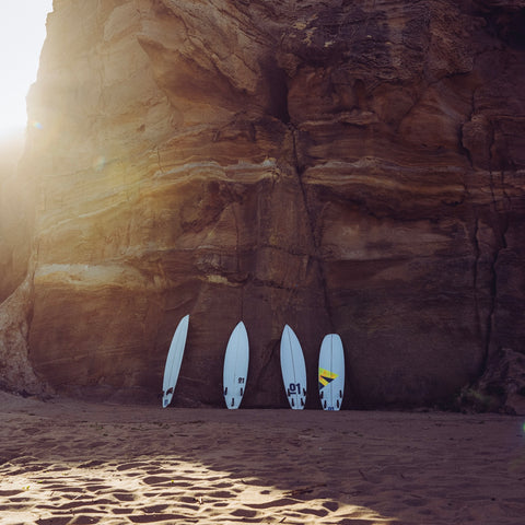Custom surfboards against a cliff