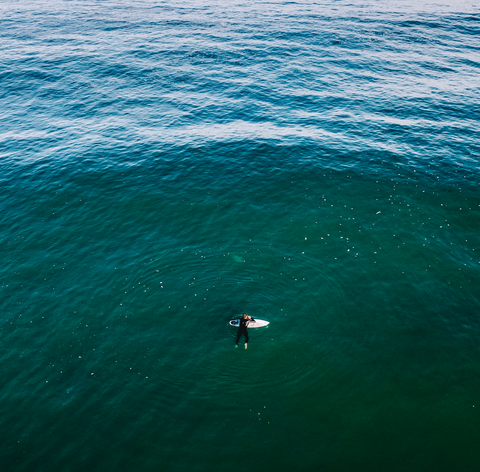 Surfer waits for a wave with a custom surfboard