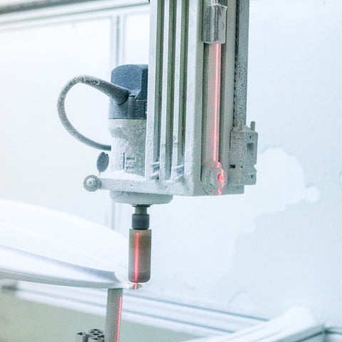 A CNC machine cutting a surfboard blank.