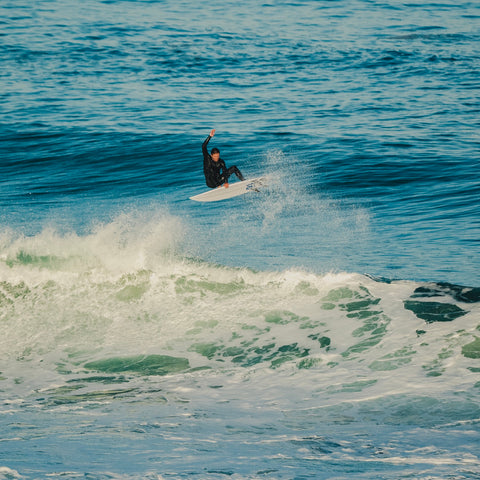A surfer does a frontside air on a custom board