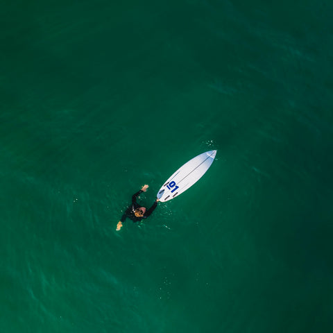 A surfer floats with a custom board
