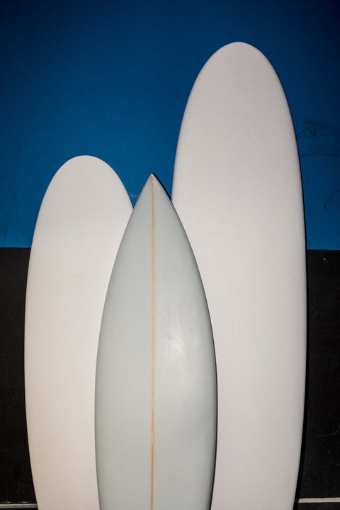 Three surfboards together in a factory. 